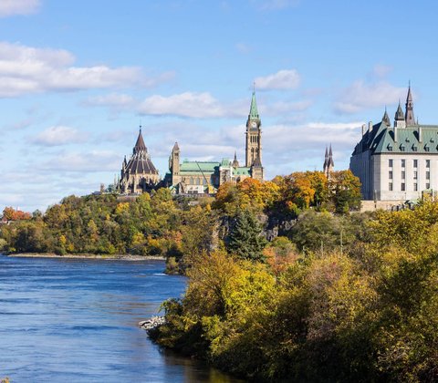 Aaron Tibben standing infront of the Ottawa parliment buildings